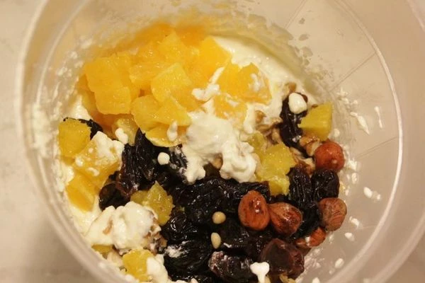 Соединить полученную массу с творогом, тщательно взбить миксером, в конце влить тонкой струйкой растопленный желатин. Добавить орехи, цукаты, аккуратно перемешать.