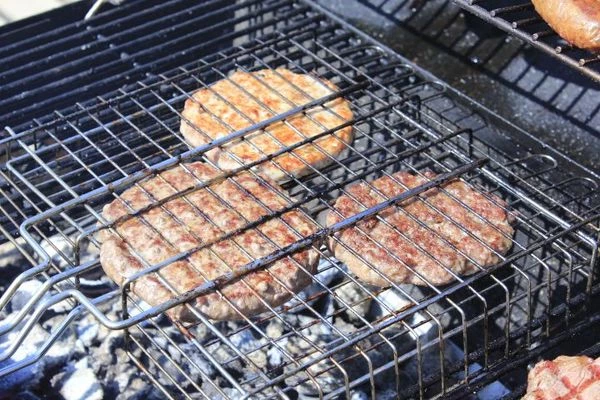 Котлету разморозить естественным способом на нижней полке холодильника. Посолить, поперчить. Обжарить до готовности на решетке над углями.