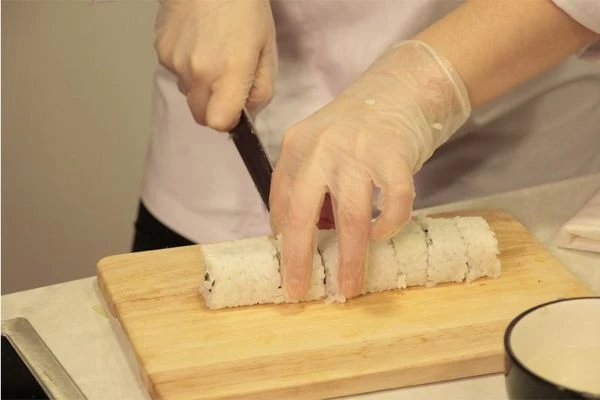 Теперь размороженное мясо краба разделить на мелкие полоски. Огурец нарезать тонкой соломкой по длине ролла. Лук нарезать тонким длинным пером.