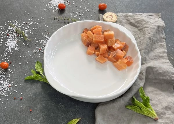 Лосось разморозить, снять филе с кожи, нарезать кубиками. Выложить в форму для запекания.
