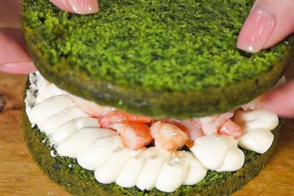 По внешнему краю коржа отсадить крем, в середину выложить креветки с соусом. Сверху положить корж.