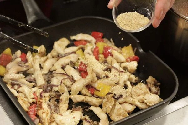 Затем добавить в получившуюся смесь кунжут и томатный соус, обжарить еще 2-3 минуты.