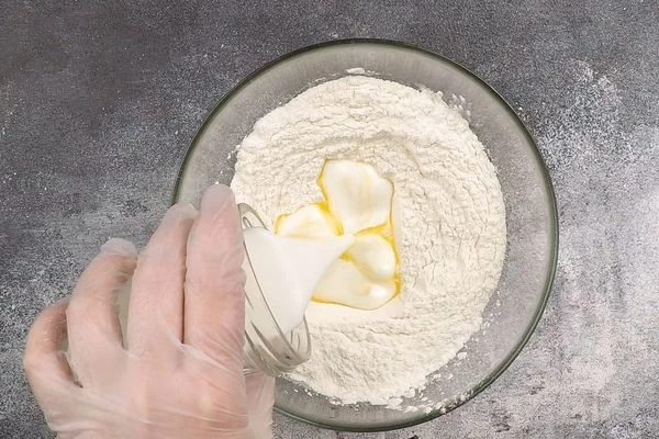 Затем добавить кефир и растопленное масло, замесить тесто.