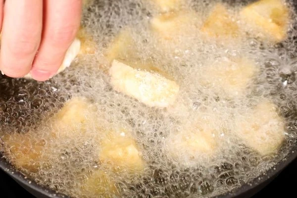 Тем временем разогреть масло, выложить баклажаны и жарить до готовности. Готовые баклажаны выложить на бумажное полотенце, затем в миску.