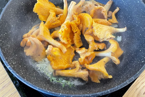 Лисички промыть, обсушить, обжарить на смеси оливкового и сливочного масла, с добавлением чеснока и веточки тимьяна. Посолить и поперчить.