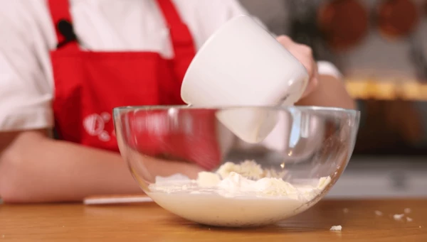 Смешать сливки и натертую на терке моцареллу. Соус посолить, поперчить, перемешать. Фрикадельки выложить в форму для запекания. Залить соусом фрикадельки. Запекать при 180°C 15 минут.
