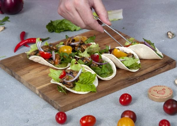 На мидии выложить нарезанные помидоры, лук и перец чили.