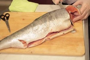 Кету разморозить естественным способом на нижней полке холодильника. Промыть,обсушить бумажным полотенцем. Отрезать голову,плавники. 