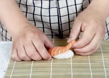 Слепите из риса шарики для суши.