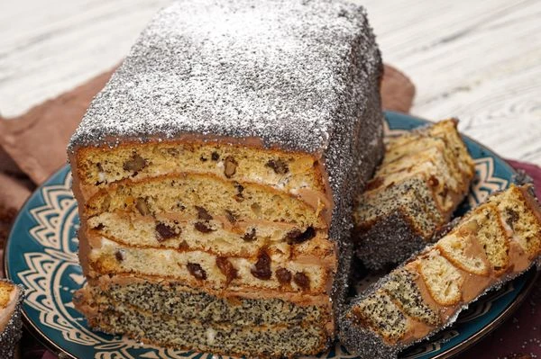 Украшаем поверхность торта маком и сахарной пудрой.