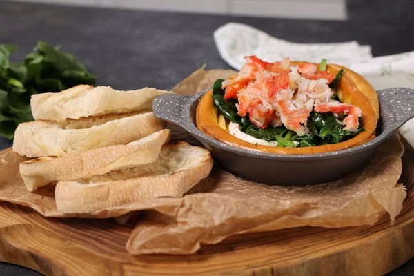 Затем обжаренный шпинат и мясо краба. Рядом выложить ломтики чиабатты. Приятного аппетита!