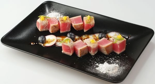 Нарезать готового тунца на кубики 2*2 см, выложить на тарелку. Украсить овощами и ягодой, полейть дрессингом.