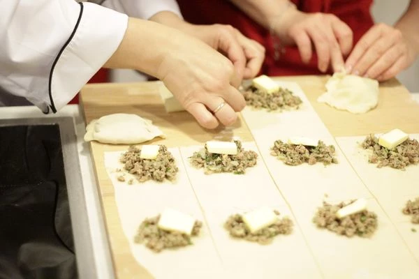 Раскатанное тесто нарезать на прямоугольники, с краю выложить начинку и по 1 кусочку сливочного масла на фарш. Закрыть второй половинкой теста и хорошо защипать края.