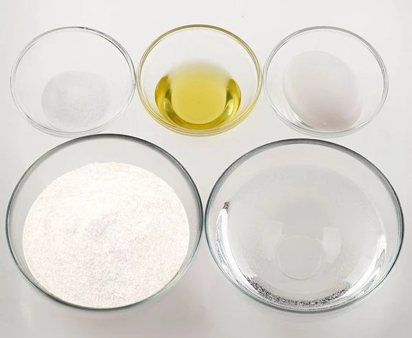 Приготовить тесто для украшения. Для этого смешать яйцо, соль, воду, масло растительное. Всыпать муку и замесить эластичное тесто, как на пельмени. Накрыть пищевой пленкой и дайте постоять 5-7 минут.