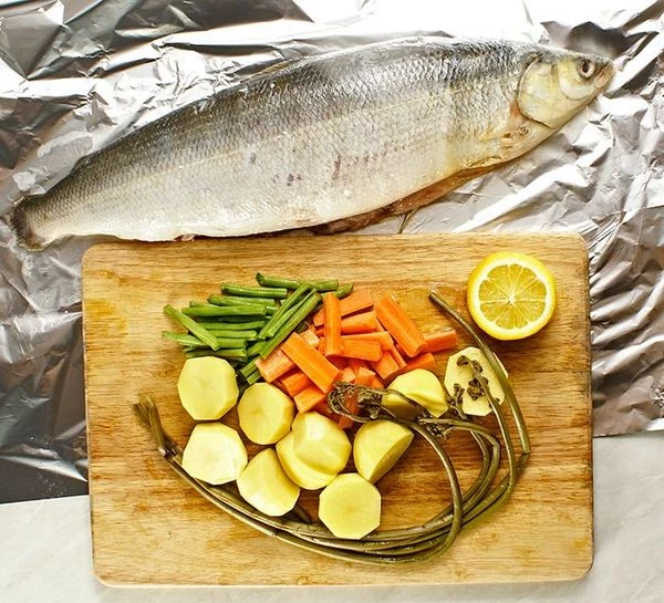 Омуля разморозить естественным способом на нижней полке холодильника. Снять под водой чешую. Разрезать вдоль брюшка и удалить внутренности, промыть. Овощи почистить, нарезать крупно. Папоротник вымочить в течении 24 часов, периодически меняя воду.