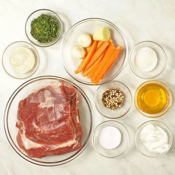 Если свинина замороженная, то разморозить естественным способом на нижней полке холодильника. Мясо промыть, обсушить бумажным полотенцем. Морковь нарезать длинными брусочками, чеснок на небольшие кусочки.