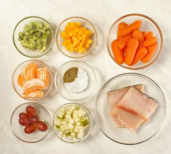  Морковь-мини отварить, хурму, киви и грушу нарезать мелким кубиком. Мандарин очистить (нам понадобится сок). Чира разморозить естественным способом на нижней полке холодильника, разделать на чистое филе на коже без костей. Нарезать на прямоугольные кусочки.