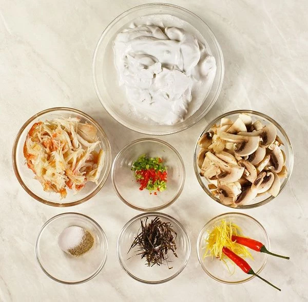 Мясо краба очистить от хитиновых пластин. Шампиньоны промыть, обсушить и нарезать тонкими пластиками. У перца чили удалить семена. Лук зеленый нарезать тонкой крошкой, водоросли нори и цедру лимона нарезать тонкой соломкой.