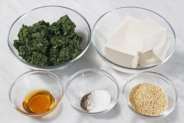 Шпинат разморозить, опустить на 1 минуту в подсоленную кипящую воду. Затем слить воду и слегка отжать. Если вы используете свежий шпинат, то промыть его под проточной водой и ошпарить кипящей подсоленной водой 2-3 минуты, чтобы он не поменял цвет, порубить мелко ножом.