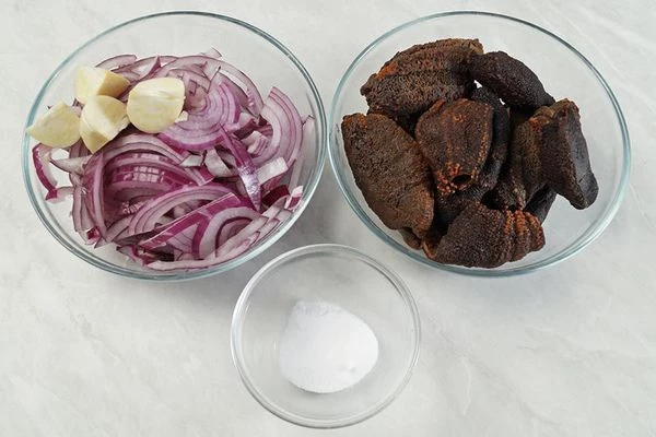 Кукумарию разморозить естественным способом на нижней полке холодильника. Лук нарезать тонким полукольцом, чеснок мелко порубить.