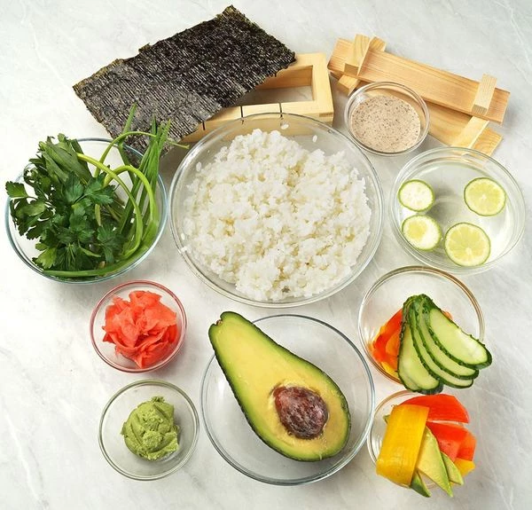 Рис сварить и заправить по предложенному рецепту от Деликатески. Нарезать тонкими ломтиками сладкий перец, аккуратно снять кожицу острым ножом. Подготовить васаби, смешав небольшое количество сухого порошка с водой или использовать уже готовый.