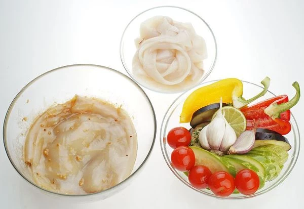 Кальмара разморозить естественным способом на нижней полке холодильника. Удалить внутренности. Обдать кипятком, смыть свернувшуюся кожицу. Часть тушек нарезать кольцами, другую часть кальмара разрезать с одной стороны, сделать неглубокие надрезы в виде "сеточки".