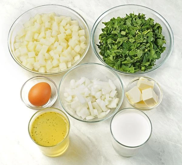 Картофель и лук почистить, нарезать кубиком 1х1 см. Сварить куриный бульон. Зелень промыть, обсушить бумажными полотенцами и нарезать не очень мелко.