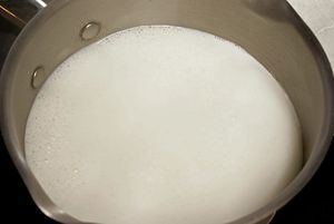 Оставшееся молоко доведите до кипения в небольшой кастрюльке. Подготовьте водяную баню