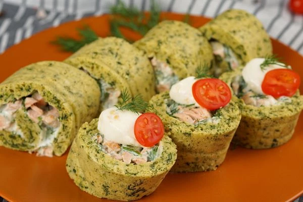 Готовый рулет нарезать на порции, украсить сыром и зеленью.