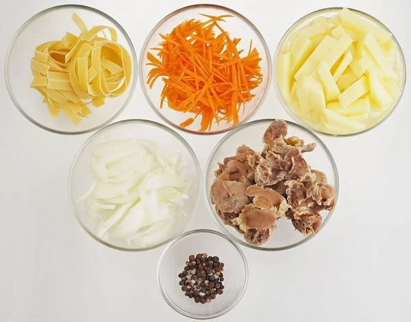 Куриные желудки промыть, залить холодной водой, варить 1-2 часа до готовности. Морковь и лук нарезать соломкой. Картофель - брусочком.