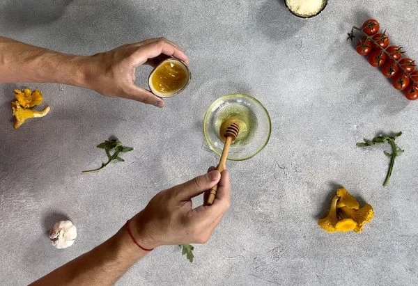 Приготовить соус, для этого смешать оливковое масло, лимонный сок, мед, соль и молотый перец. 