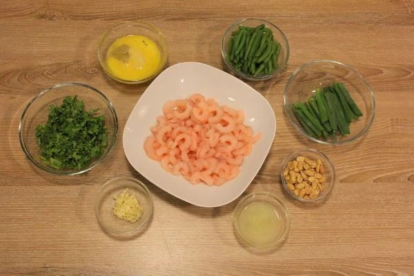 Лук нарежьте полосками, длинной 4-5см. Креветки разморозьте естественным способом на нижней полке холодильника, промойте, обсушите. Зелень кинзы мелко порубите. Арахис немного измельчите ножом.