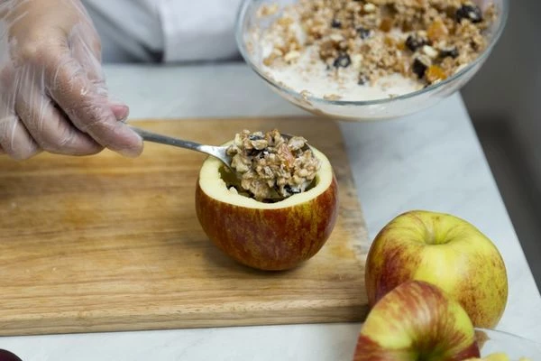 Начините яблоко получившейся смесью и поставьте в разогретую до 200С духовку на 15-20 минут, до готовности яблока.