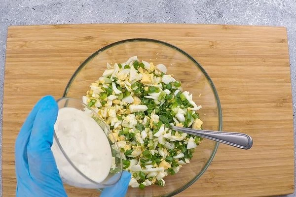 Отварить 4 яйца, нарезать кубиком, лук зеленый мелко порубить, смешать в чашке, добавив соус бешамель, посолить по вкусу.