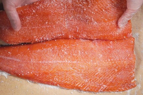 На пергамент или в стеклянный лоток выложить первое филе кожей вниз, затем сверху уложить второе филе кожей вверх.