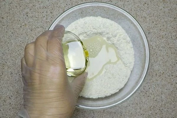 В глубокой чашке смешать муку, соль, воду и растительное масло. 