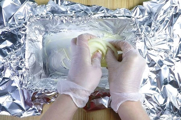 В форму для запекания застелить фольгу, смазать ½ часть сливочного масла. На дно выложить кольца лука.