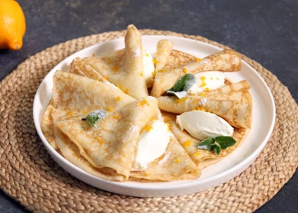 Маскарпоне и лимон.
Очень вкусные итальянские блинчики с маскарпоне и лимоном мгновенно перенесут вас на солнечный остров Сардиния. Сочетание в начинке сладковатого сливочного сыра и лимонной кислинки влюбит в себя даже тех, кто редко ест десерты. Сладкоежки могут посыпать такие блины сахарной пудрой.
Блин сложить пополам, выложить сыр, сбрызнуть лимонным соком, сложить еще раз пополам. Посыпать сахарной пудрой и цедрой лимона.
