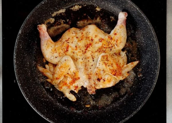 В разогретую сковороду налить растительное масло и добавить кусочек сливочного. Выложить цыпленка и обжарить до румяной корочки с двух сторон. 
