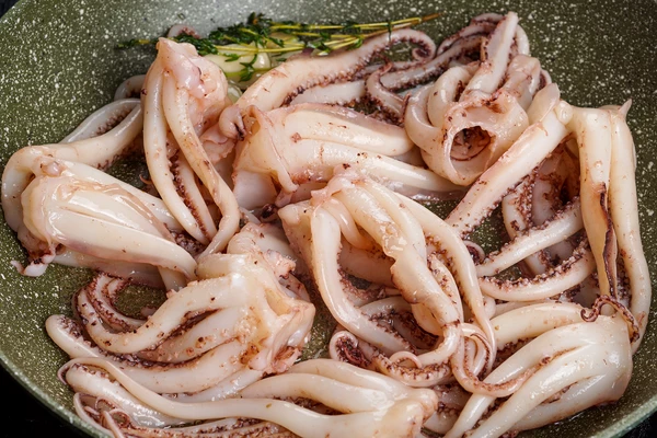 Обжарить щупальца 2-3 минуты. Можно целиком, можно разрезать на части.