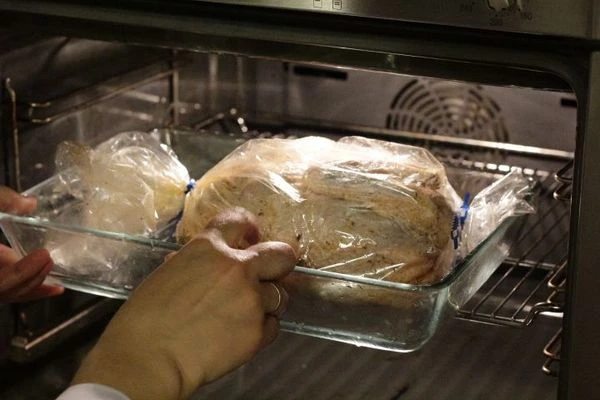 Через 1,5 часа приготовления цесарки, вынуть противень, аккуратно сверху разрезать рукав для запекания и положить в центр начинку из кус куса и кедровые орехи.