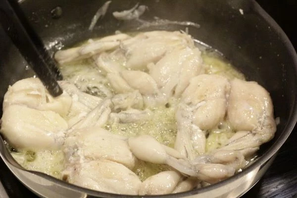 На разогретой сковороде растопить сливочное масло, обжарить лягушачьи лапки до золотистого цвета. Затем добавить зелень и тушить под закрытой крышкой 20-30 минут, до готовности мяса.