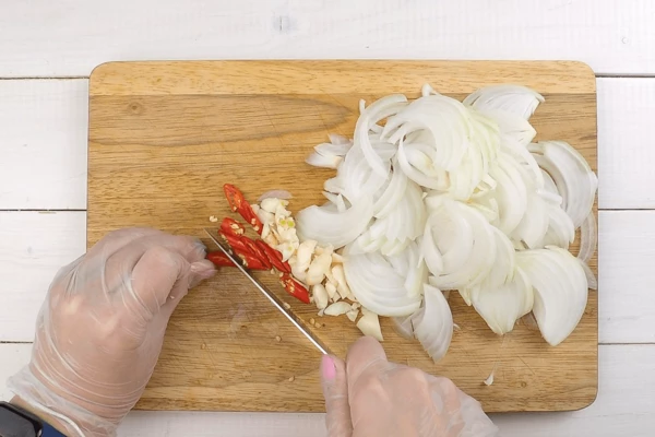 Лук репчатый нарезать полукольцами, чеснок раздавить ножом и порубить. Перец нарезать кольцами (чтобы снизить остроту, удалить семенную коробку и перегородки).