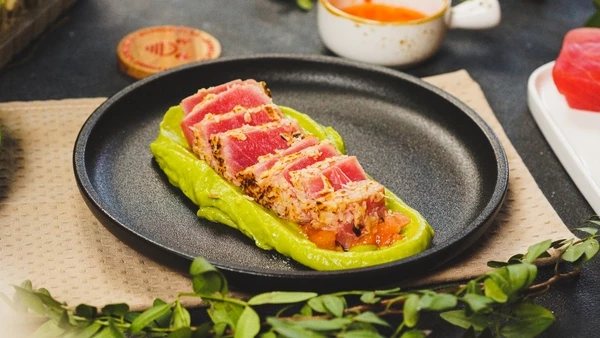 Тунец нарезать ломтиками. Томат вымыть, очистить от кожуры, нарезать мелким кубиком. На тарелку для подачи выложить соус из авокадо, затем томат. Посолить, сбрызнуть маслом. Сверху тунец. Можно подавать к столу. Приятного аппетита! 

