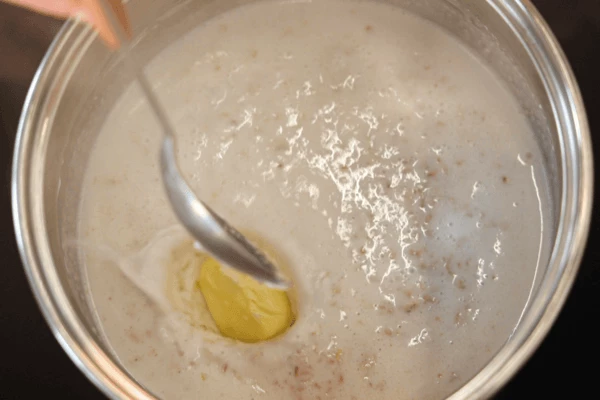 В готовую овсянку положить кусочек сливочного масла, добавить сахар и соль, перемешать, снять с огня.
