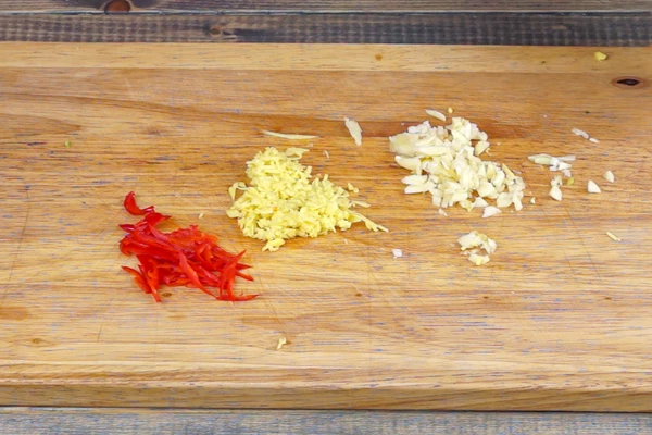  Имбирь и чеснок мелко порубить, перец чили нарезать соломкой.