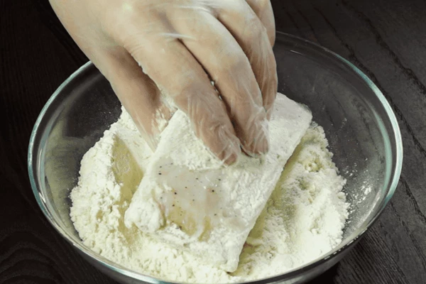 Затем подмаринованную рыбу обвалять в смеси муки, соли и перца черного.