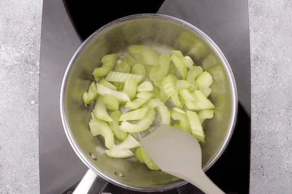 В разогретом с растительным маслом сотейнике обжарить чеснок и сельдерей примерно 3 минуты.