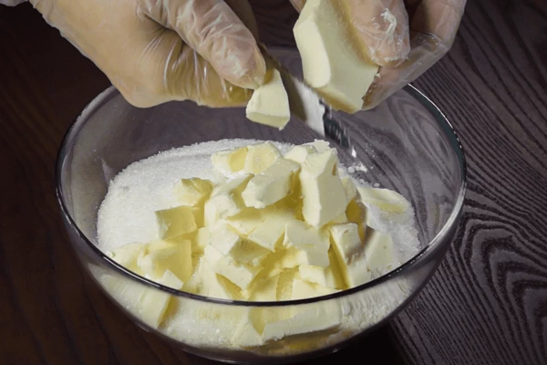 Затем добавить нарезанное кусочками сливочное масло.