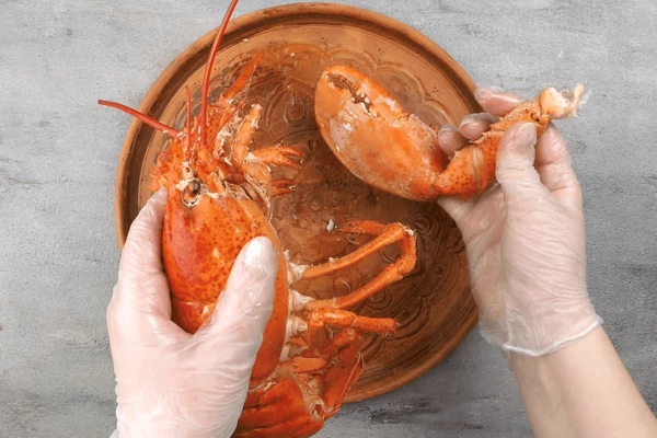 Для разделки лобстера вам понадобятся большой нож и ножницы.
Осторожно оторвите клешни, в местах, где они соединяются с телом. «Открутите» голову.